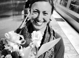 Jericha is a caucasian woman with short brown hair, holding a bouquet of flowers. The photo is in black and white.